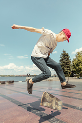 Image showing Skateboarder doing a trick at the city\'s street in sunny day