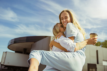 Image showing Young lesbian\'s couple preparing for vacation trip on the car in sunny day