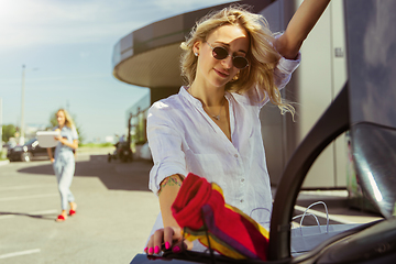 Image showing Young lesbian\'s couple preparing for vacation trip on the car in sunny day