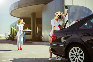 Image showing Young lesbian\'s couple preparing for vacation trip on the car in sunny day