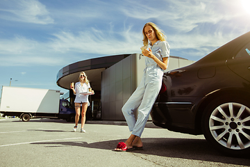 Image showing Young lesbian\'s couple preparing for vacation trip on the car in sunny day