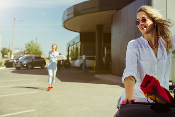 Image showing Young lesbian\'s couple preparing for vacation trip on the car in sunny day