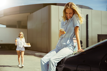 Image showing Young lesbian\'s couple preparing for vacation trip on the car in sunny day