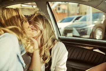 Image showing Young lesbian\'s couple preparing for vacation trip on the car in sunny day