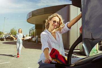 Image showing Young lesbian\'s couple preparing for vacation trip on the car in sunny day