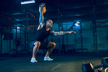 Image showing Young healthy man athlete doing exercise in the gym