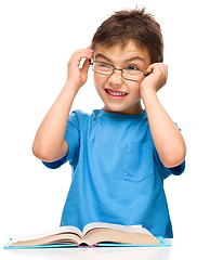 Image showing Little boy is reading a book