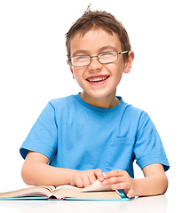 Image showing Little boy is reading a book