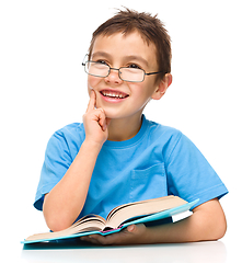 Image showing Little boy is reading a book