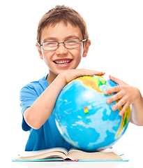 Image showing Little boy is examining globe