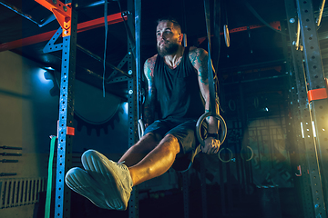 Image showing Young healthy man athlete doing exercise in the gym