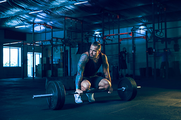 Image showing Young healthy man athlete doing exercise in the gym