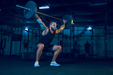 Image showing Young healthy man athlete doing exercise in the gym