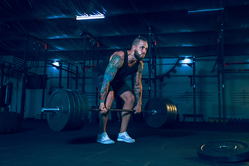 Image showing Young healthy man athlete doing exercise in the gym