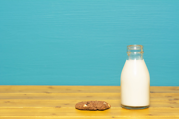 Image showing Milk in a glass bottle and a chocolate chip cookie