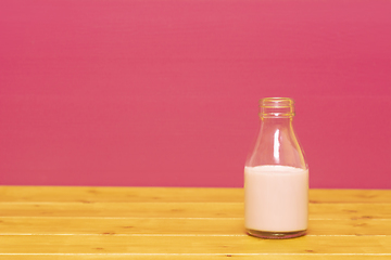 Image showing One-third pint milk bottle half full with strawberry milkshake