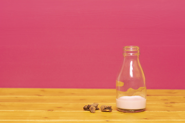 Image showing Bottle half full of strawberry milkshake with cookie crumbs