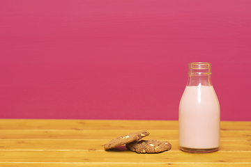 Image showing Strawberry milkshake in a glass milk bottle with a cookie