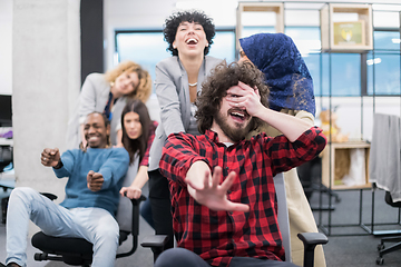 Image showing multiethnics business team racing on office chairs