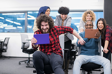 Image showing multiethnics business team racing on office chairs