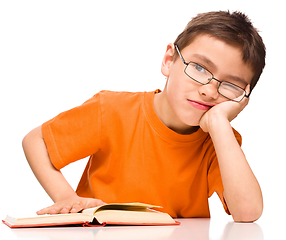 Image showing Little boy is tired to read his book