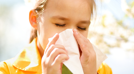 Image showing Little girl is blowing her nose