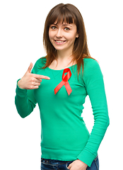 Image showing Woman is pointing to the red awareness ribbon