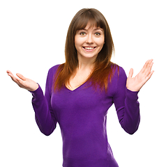 Image showing Portrait of a young woman raised her hands up