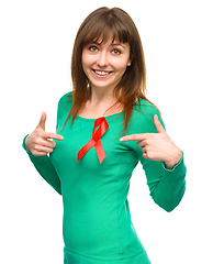 Image showing Woman is pointing to the red awareness ribbon