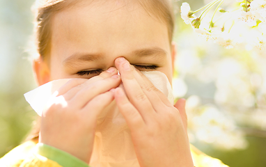 Image showing Little girl is blowing her nose