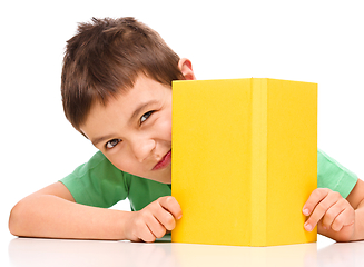 Image showing Little boy plays with book