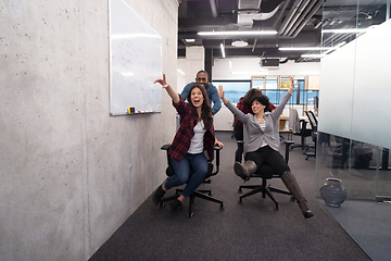 Image showing multiethnics business team racing on office chairs