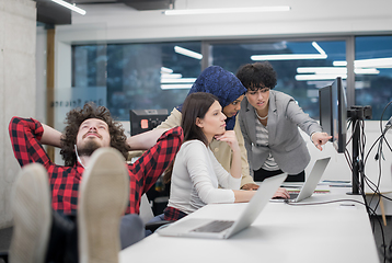 Image showing software developer resting with legs on desk