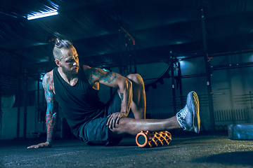 Image showing Young healthy man athlete doing exercise in the gym