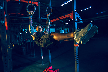 Image showing Young healthy man athlete doing exercise in the gym