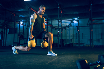 Image showing Young healthy man athlete doing exercise in the gym