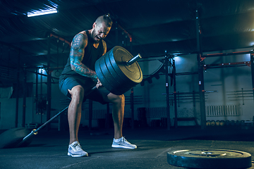 Image showing Young healthy man athlete doing exercise in the gym