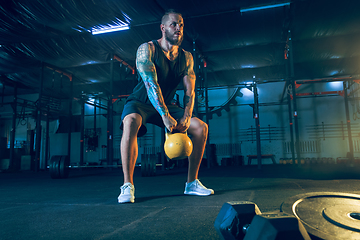 Image showing Young healthy man athlete doing exercise in the gym