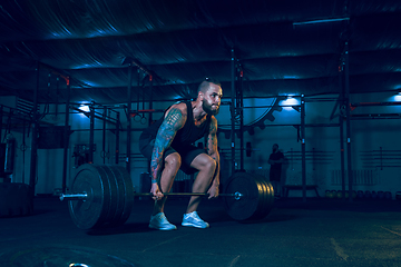 Image showing Young healthy man athlete doing exercise in the gym