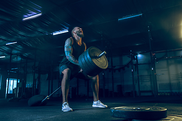 Image showing Young healthy man athlete doing exercise in the gym