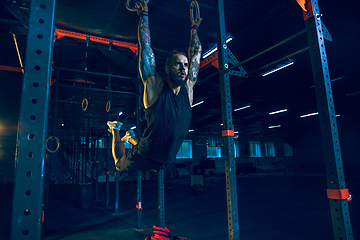 Image showing Young healthy man athlete doing exercise in the gym