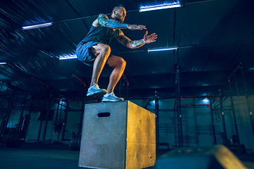 Image showing Young healthy man athlete doing exercise in the gym