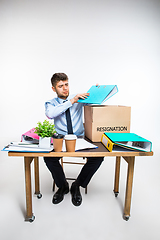 Image showing The young man is resigned and folds things in the workplace