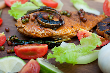 Image showing wood fired hoven cooked chicken breast on wood board 