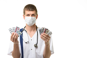 Image showing Portrait of doctor with medications in hands, isolated on white background