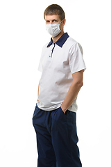 Image showing Portrait of a doctor in a medical mask on a white background, the doctor put his hands in his pockets