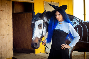 Image showing Portrait of a witch with a horse on which a skeleton is painted in white paint