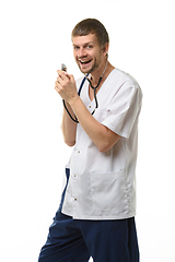 Image showing Cheerful doctor singing into impromptu microphone from phonendoscope head isolated on white background