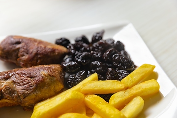 Image showing Roast duck breast with plums and fries served on dish