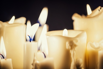 Image showing Candles glowing against dark background